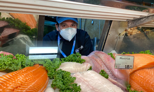 Member looking through a seafood display case for a picture