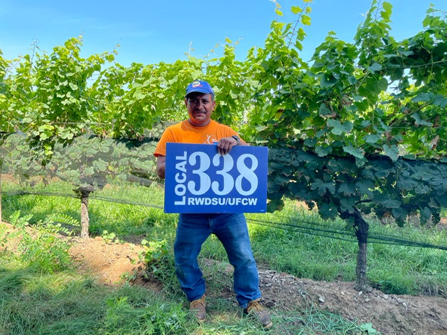 Farm Worker Member holding a Local 338 Sign