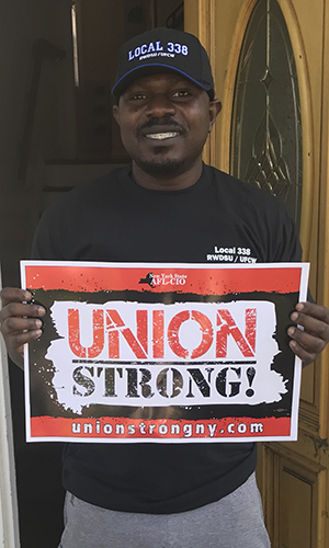 Member outside a door holding a sign that says union strong